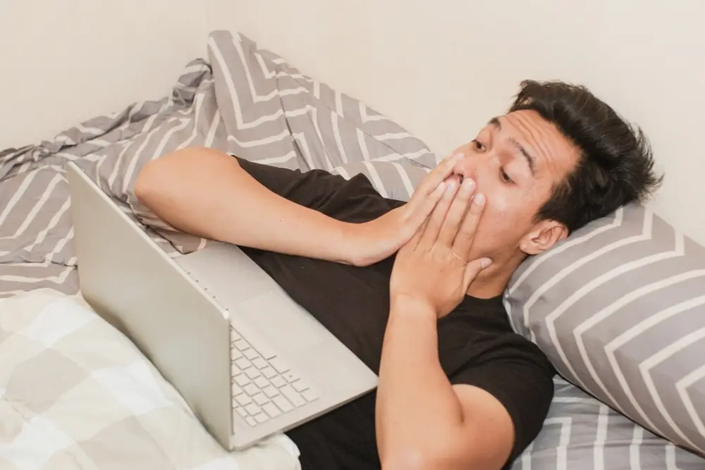 Vyděšený muž sleduje notebook