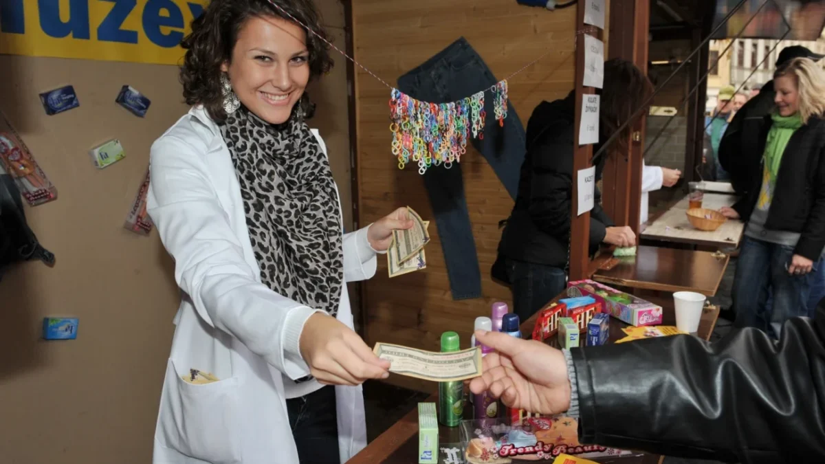 žena za pultem na tržišti prodává retro předměty