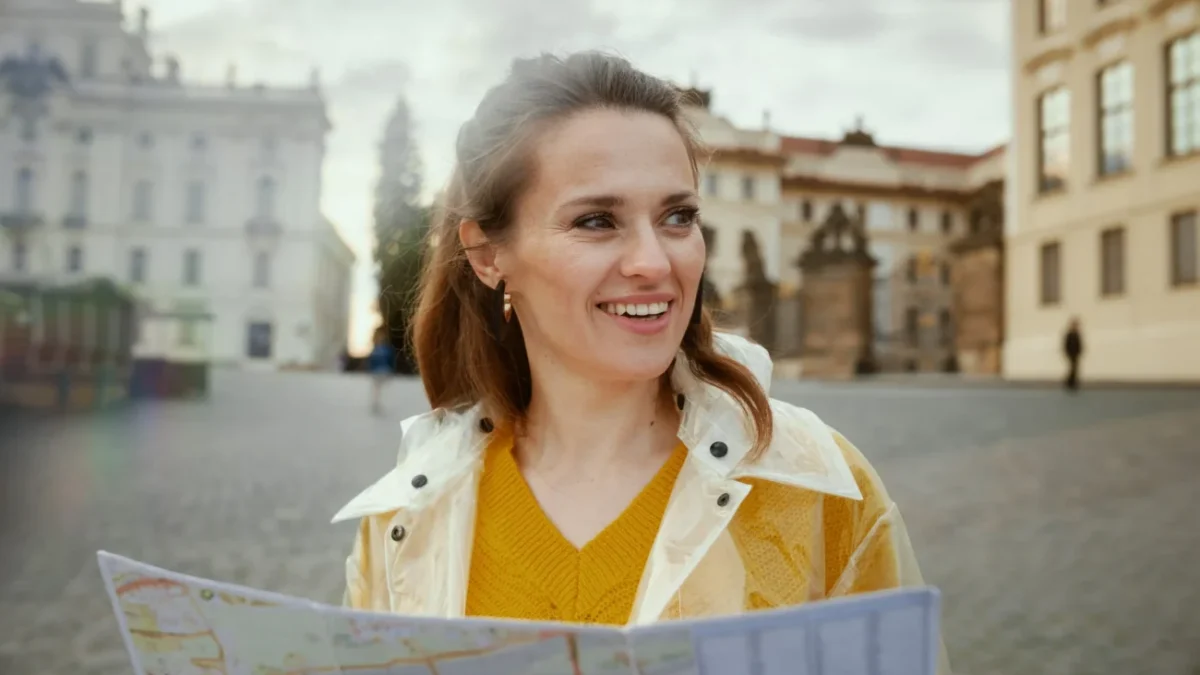 Žena ve žlutém svetru koukající do mapy.