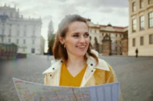 Žena ve žlutém svetru koukající do mapy.