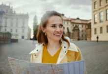 Žena ve žlutém svetru koukající do mapy.
