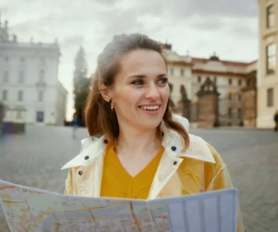 Žena ve žlutém svetru koukající do mapy.