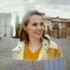 Žena ve žlutém svetru koukající do mapy.