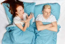 Žena a muž vedle sebe leží naštvaní v posteli.