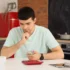 Muž sedící u stolu a přepočítávající peníze.
