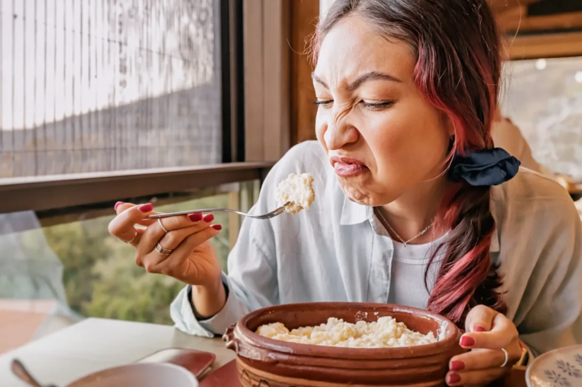 Žena se zhnusením jí jídlo.