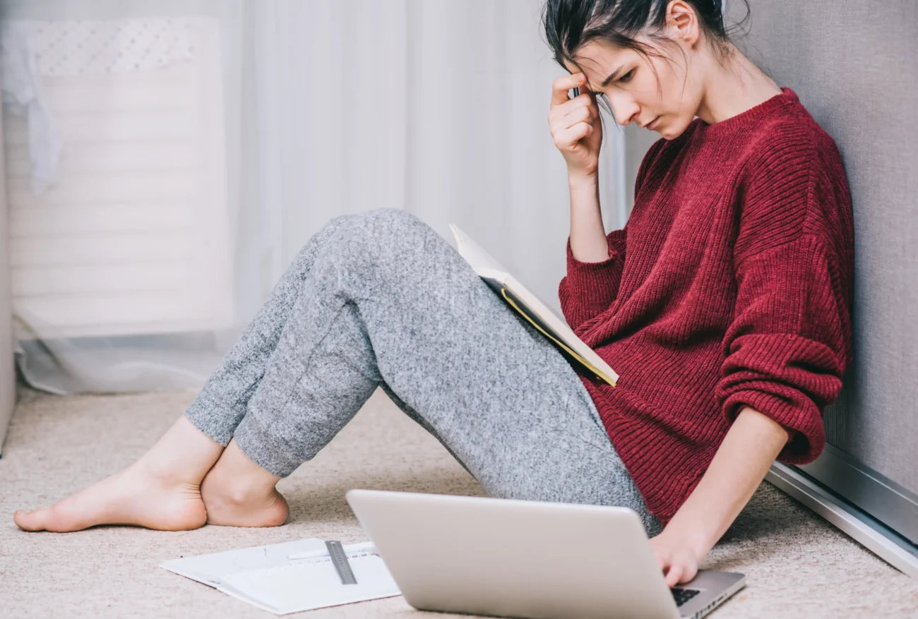 shutterstock_792108352-2 | TVGURU.cz Žena je neštastná a sedí na zemi u notebooku.