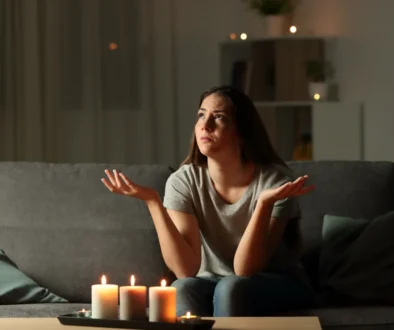Žena sedí při svíčkách, protože je bez proudu.