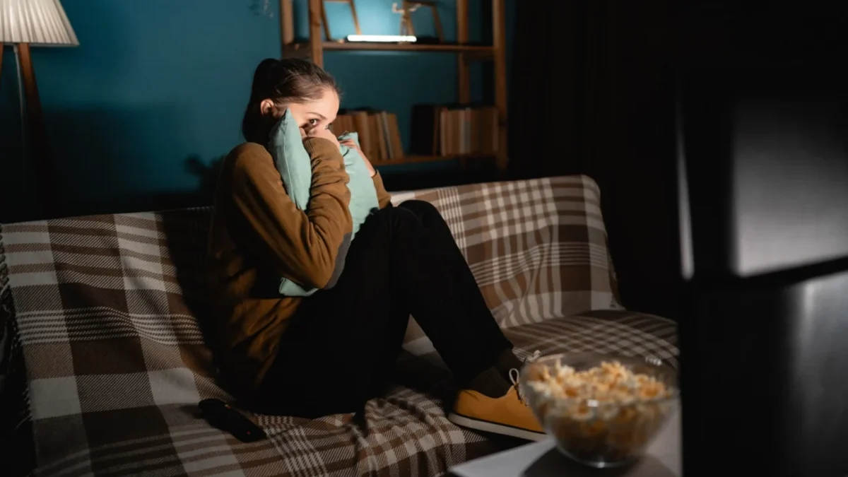 Žena sleduje hororový film.