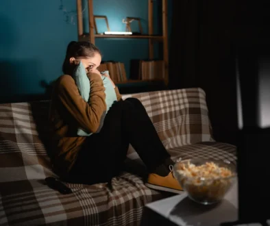 Žena sleduje hororový film.