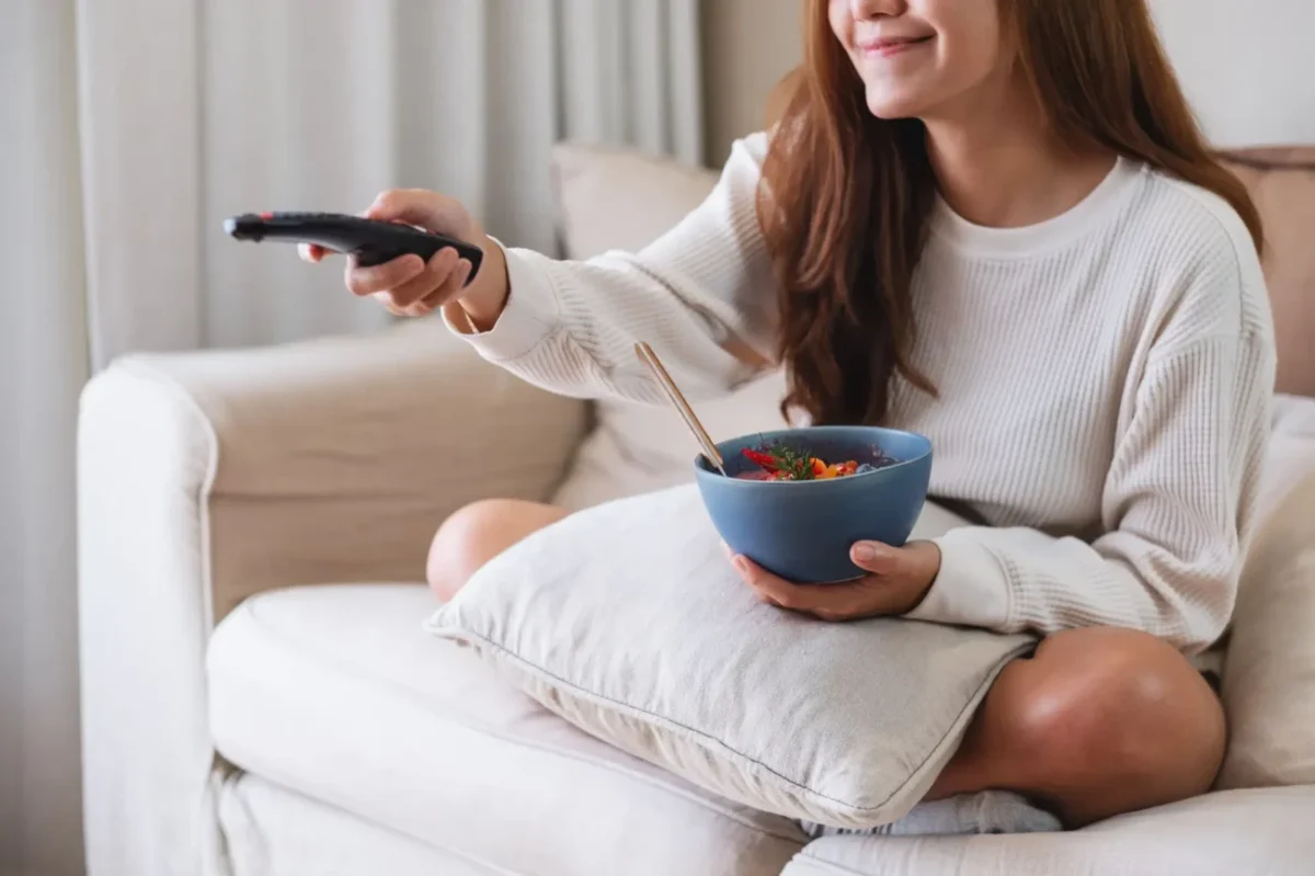 mladá žena snídá u televize