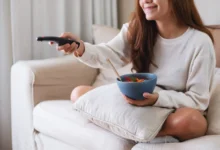 mladá žena snídá u televize
