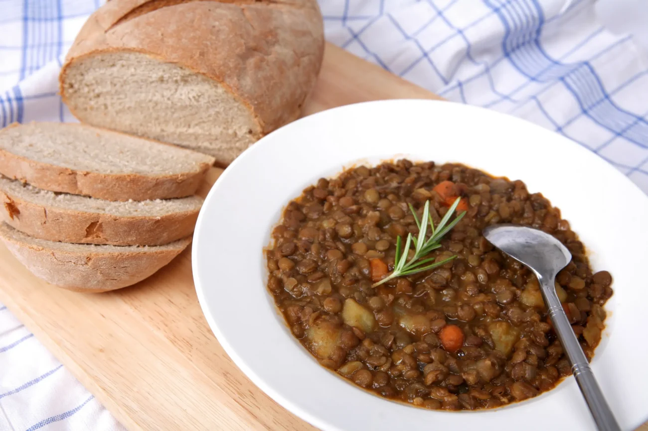shutterstock_16907356-2 | TVGURU.cz Čočková polévka a chléb leží na stole.