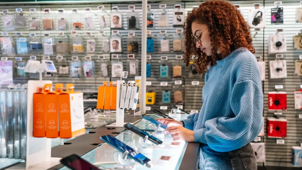 Žena si v obchodě vybírá telefon.