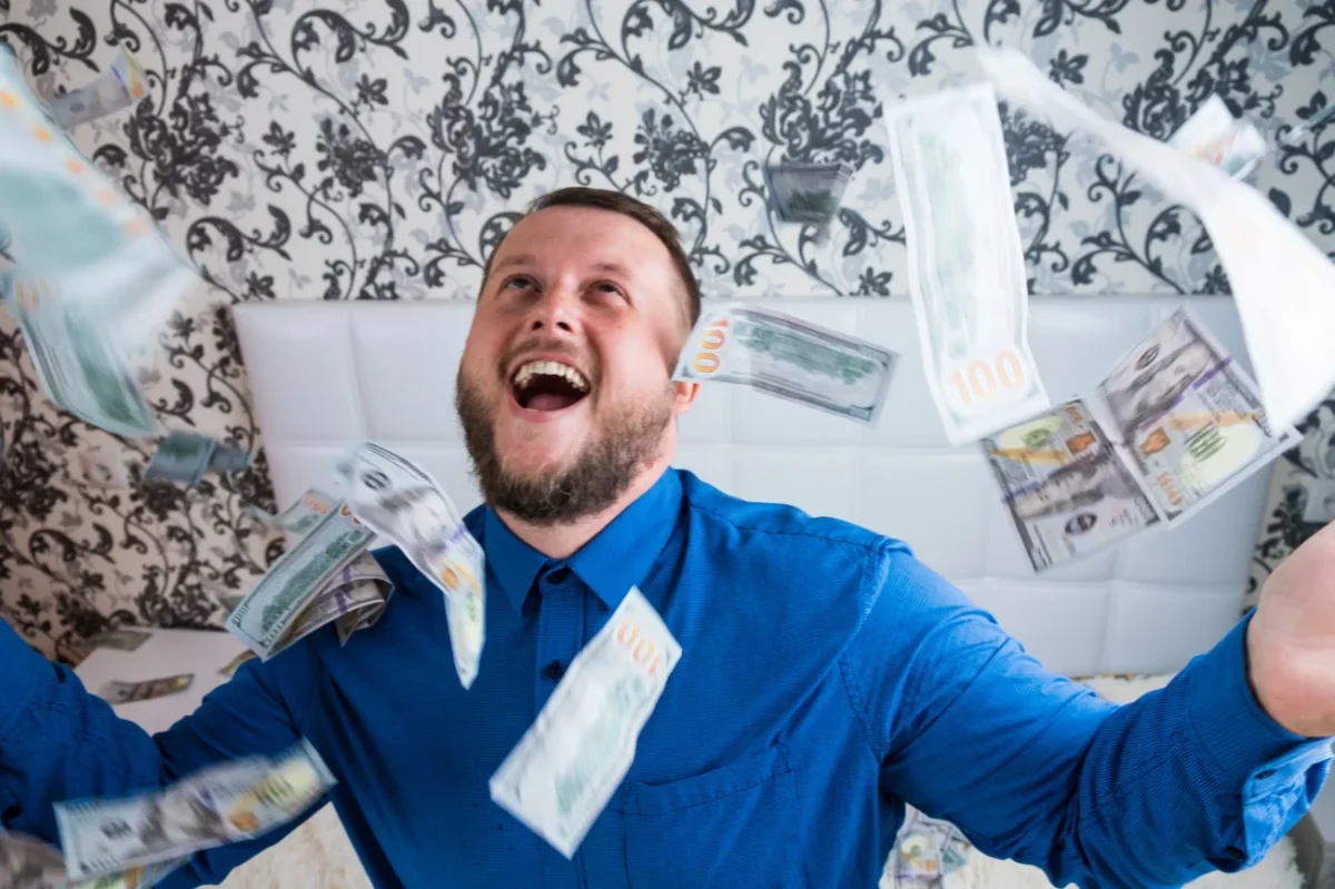 Muž rozhazuje penězi.
