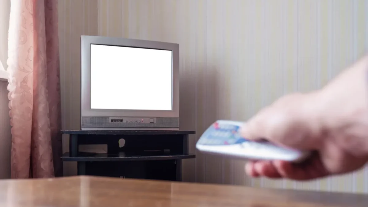 Muž zapínající starou televizi