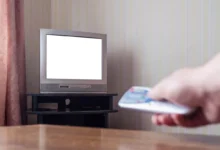 Muž zapínající starou televizi