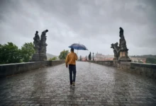 muž jde v dešti přes most