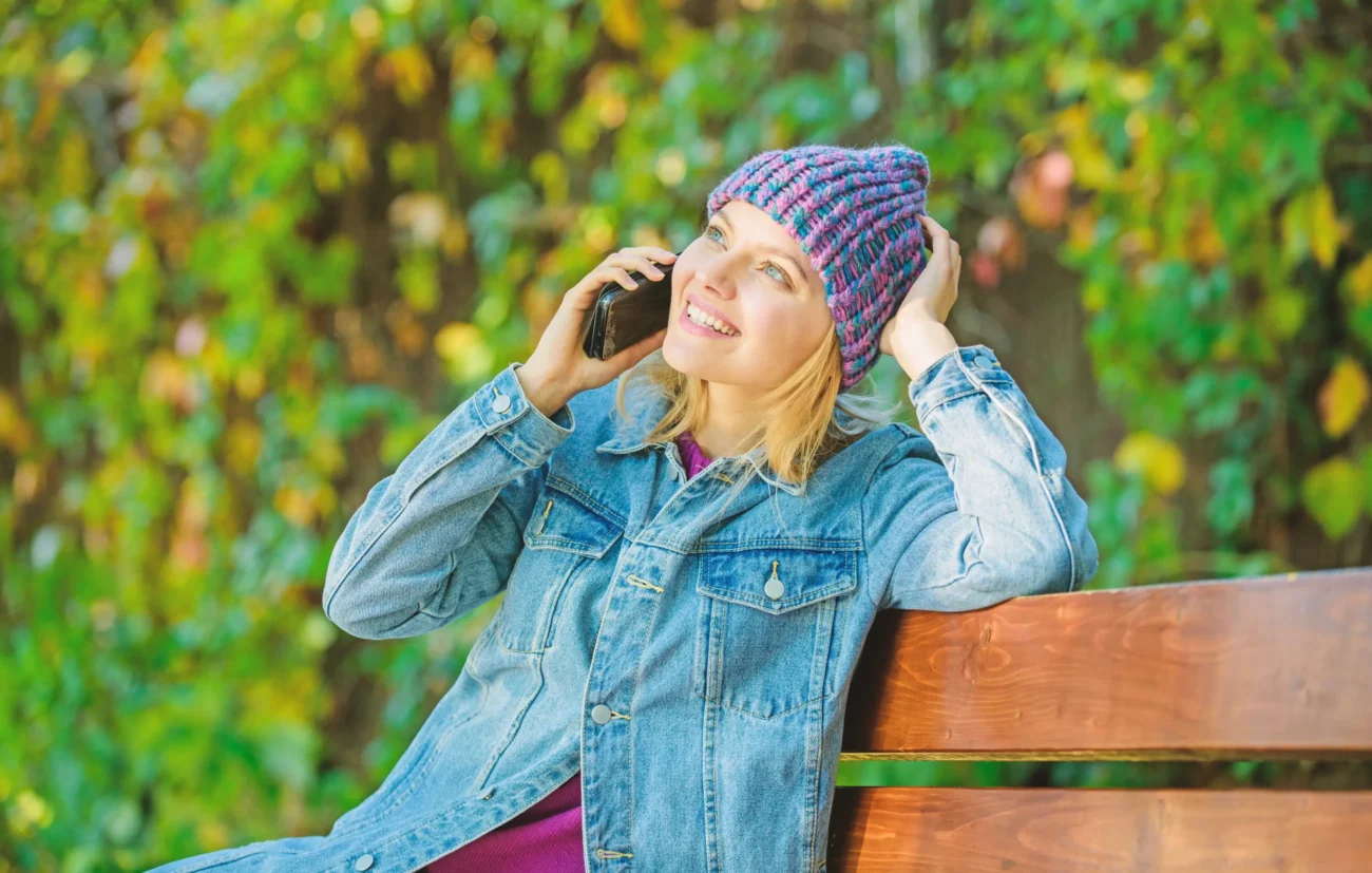 shutterstock_1428461234-2-2 | TVGURU.cz Žena sedí na lavičce a telefonuje.