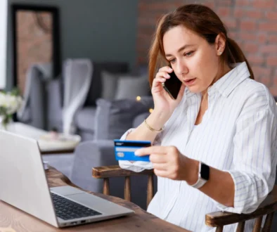 Žena telefonuje, dívá se do notebooku a opisuje údaje z karty.