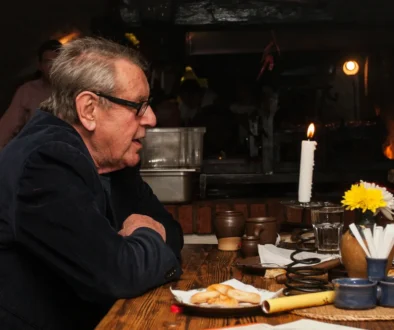 Miloš Forman sedí u stolu.
