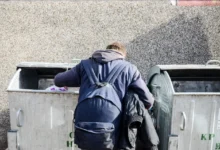 Muž prohlédává popelnice.