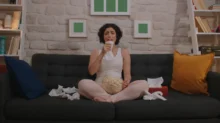 Žena je obklopená posmrkanými kapesníčky a brečí u televize.