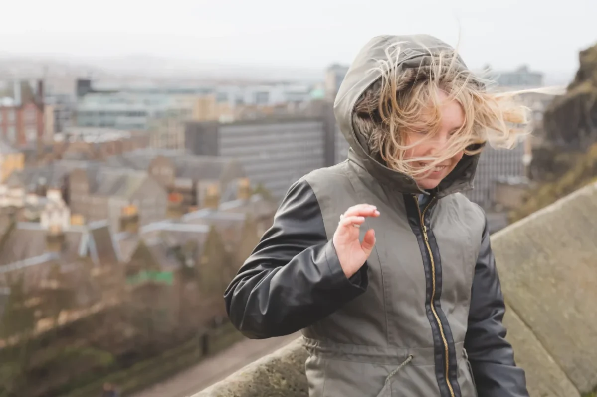 Ženě vítr rozfoukává vlasy.