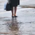 žena stojící na přechodu během vydatného deště