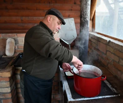 Muž vařící jídlo při zabijačce.