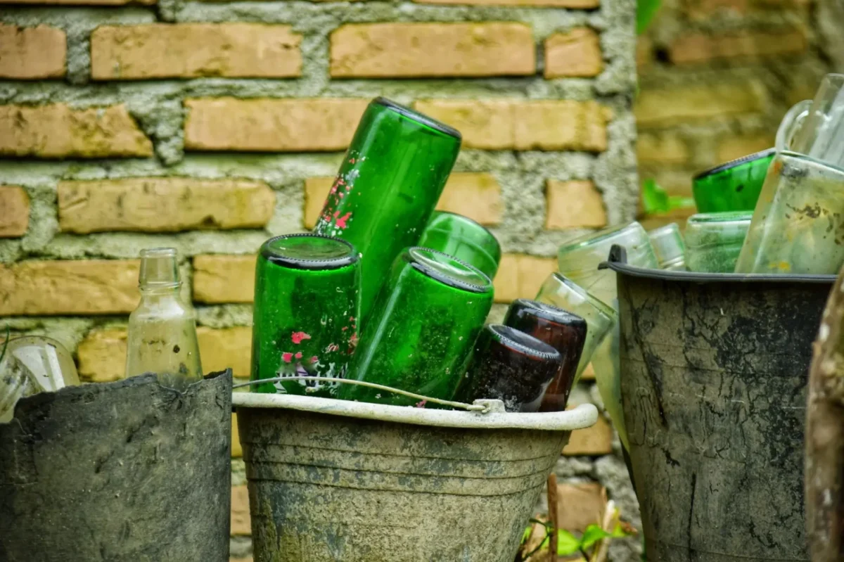 prázdné lahve od vína nastrkané do kovového kbelíku