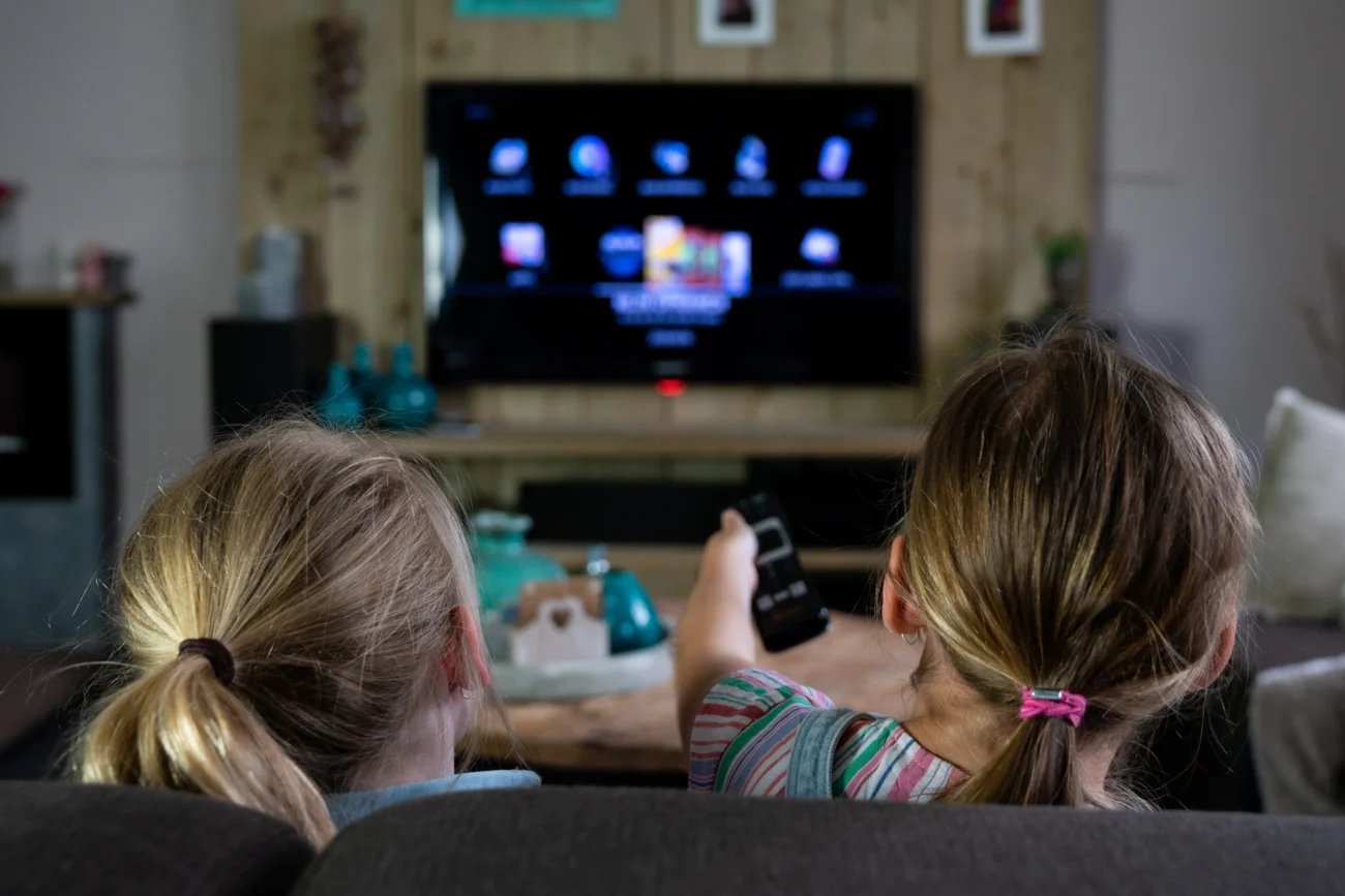 shutterstock_1398250544-2 | TVGURU.cz Děti se dívají na televizi a sedí u toho na gauči.