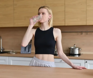 žena pije ze sklenice
