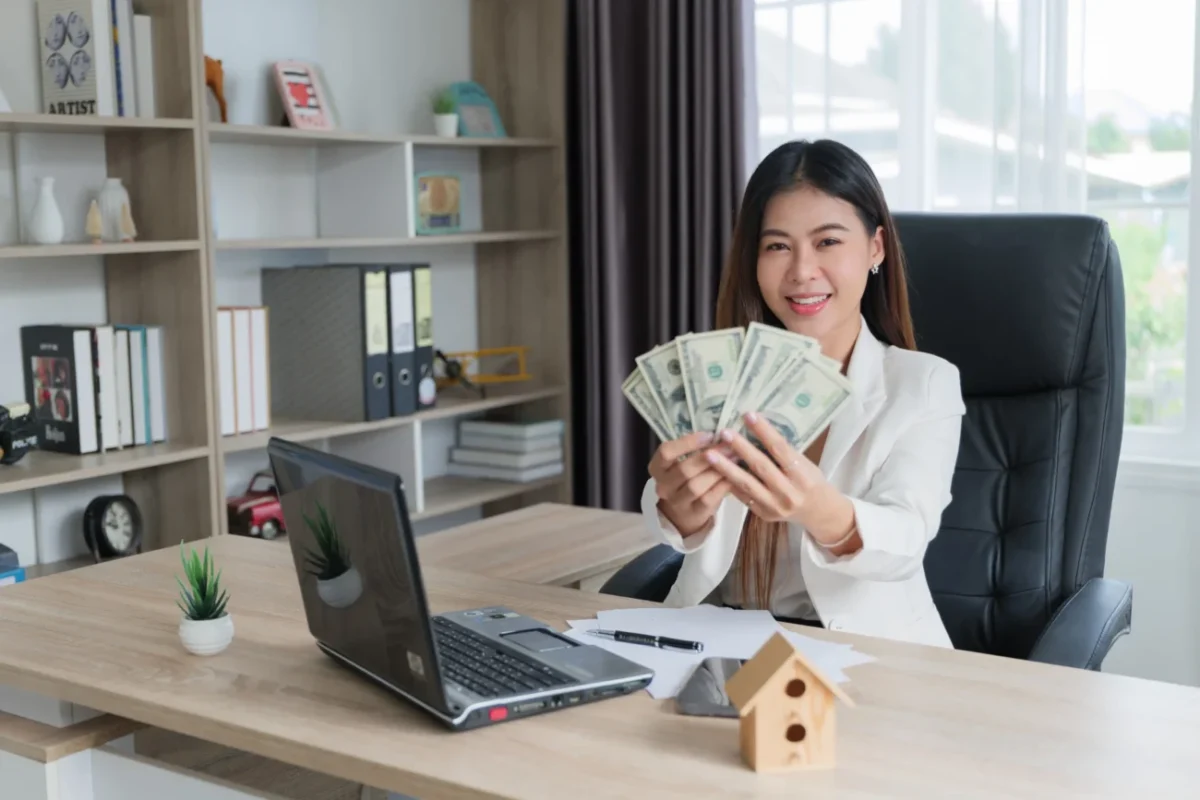 Žena s penězi a počítačem.