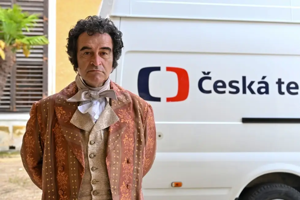V České televizi reklamy běží minimálně. Zdroj: Profimedia | TVGURU.cz Muž stojící před dodávkou Česká televize.