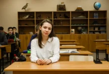 dívka sedí v lavici ve třídě