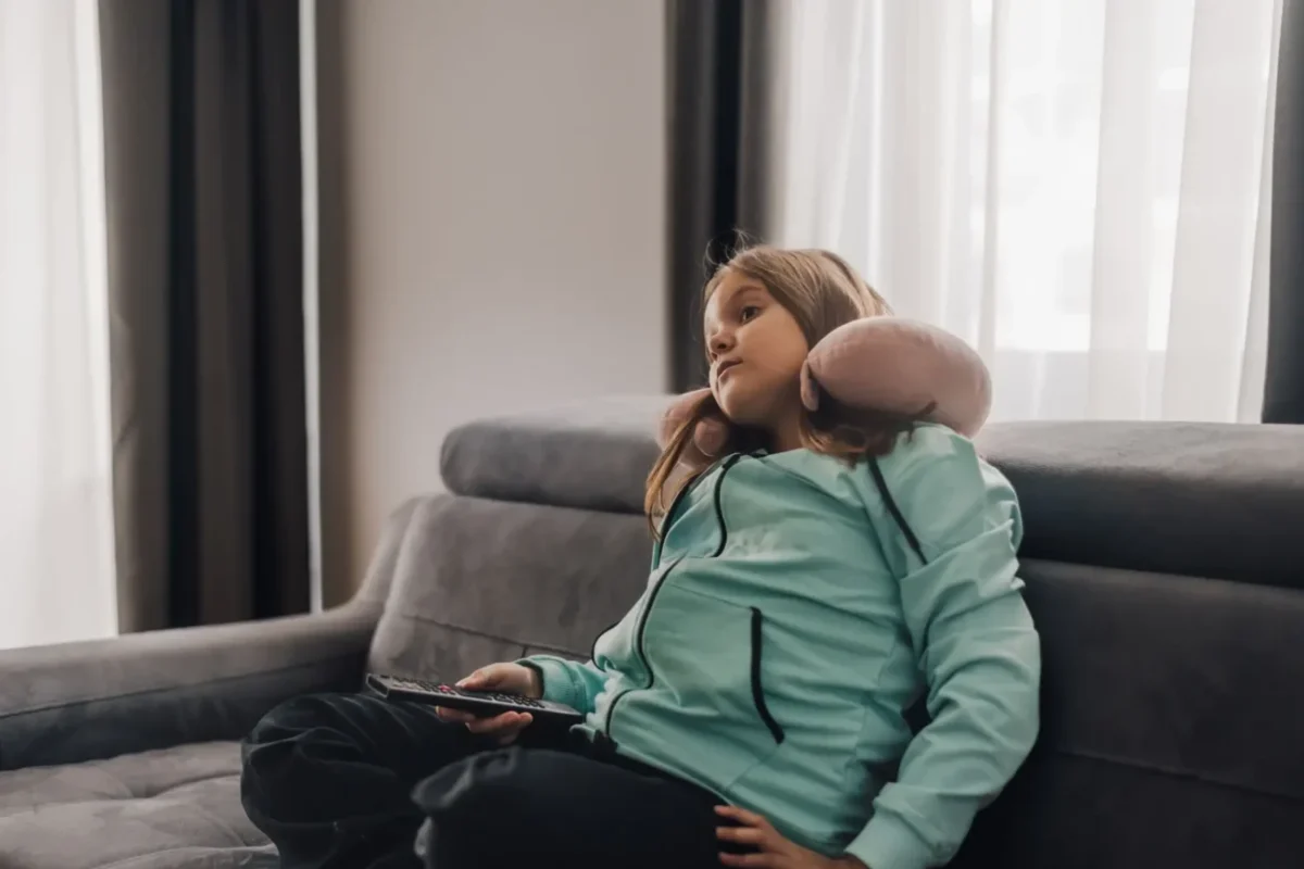 znuděná holčička z gauče sleduje televizi