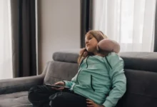 znuděná holčička z gauče sleduje televizi