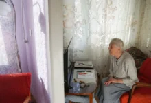 Stará paní se dívá na televizi.