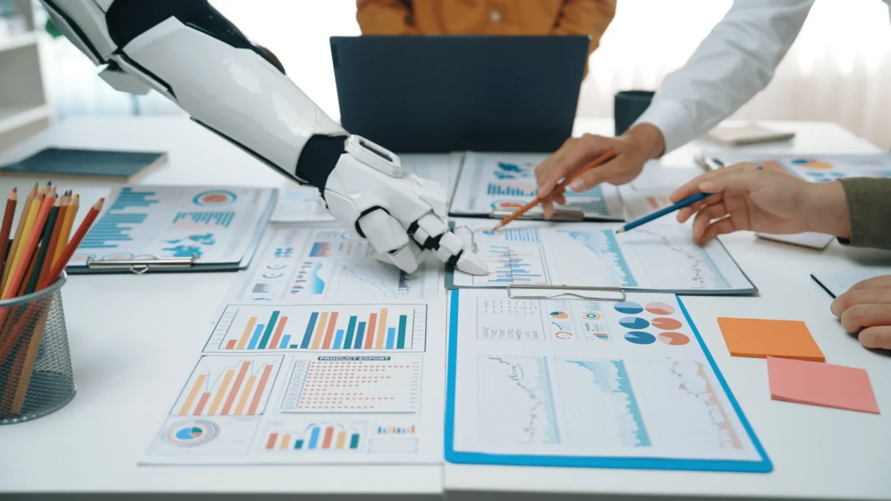 shutterstock_2615381561 | TVGURU.cz Lidé a robot ukazují na něco na papíře.