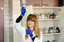 Chemička něco drží v ruce.