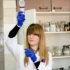 Chemička něco drží v ruce.
