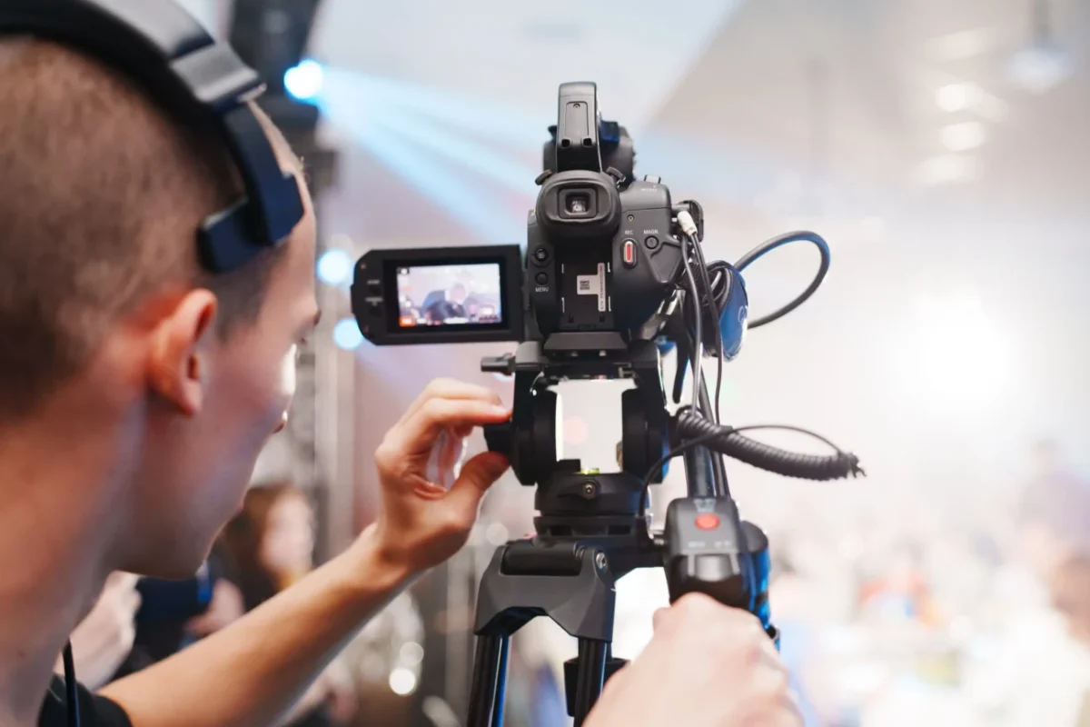 kameraman drží v ruce kameru a natáčí