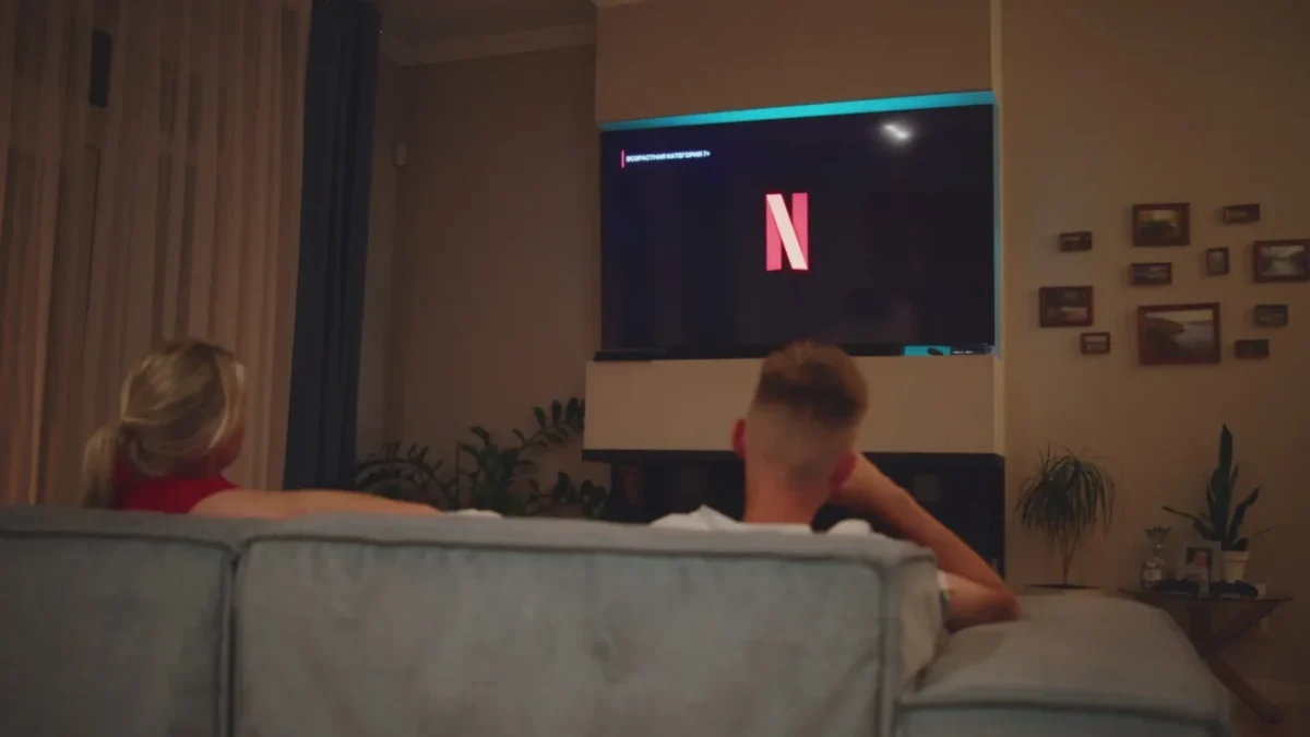 muž sleduje Netflix na televizi