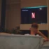 muž sleduje Netflix na televizi