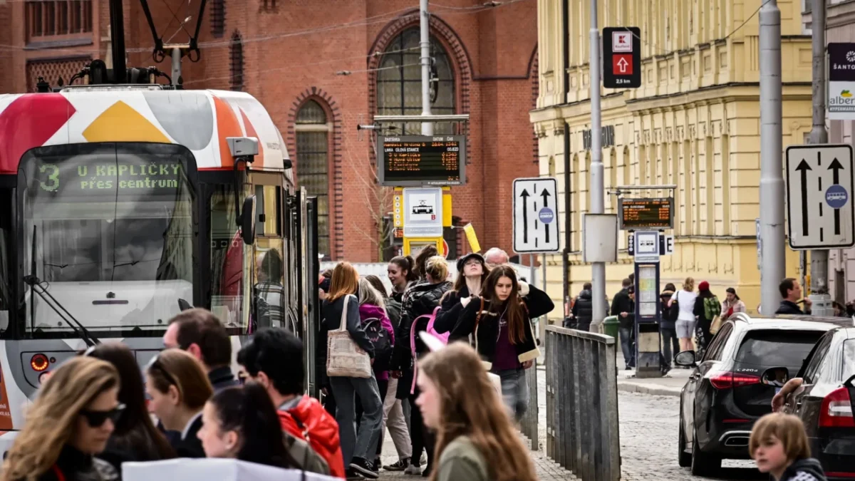 Lidé chodí kolem tramvaje v Olomouci.