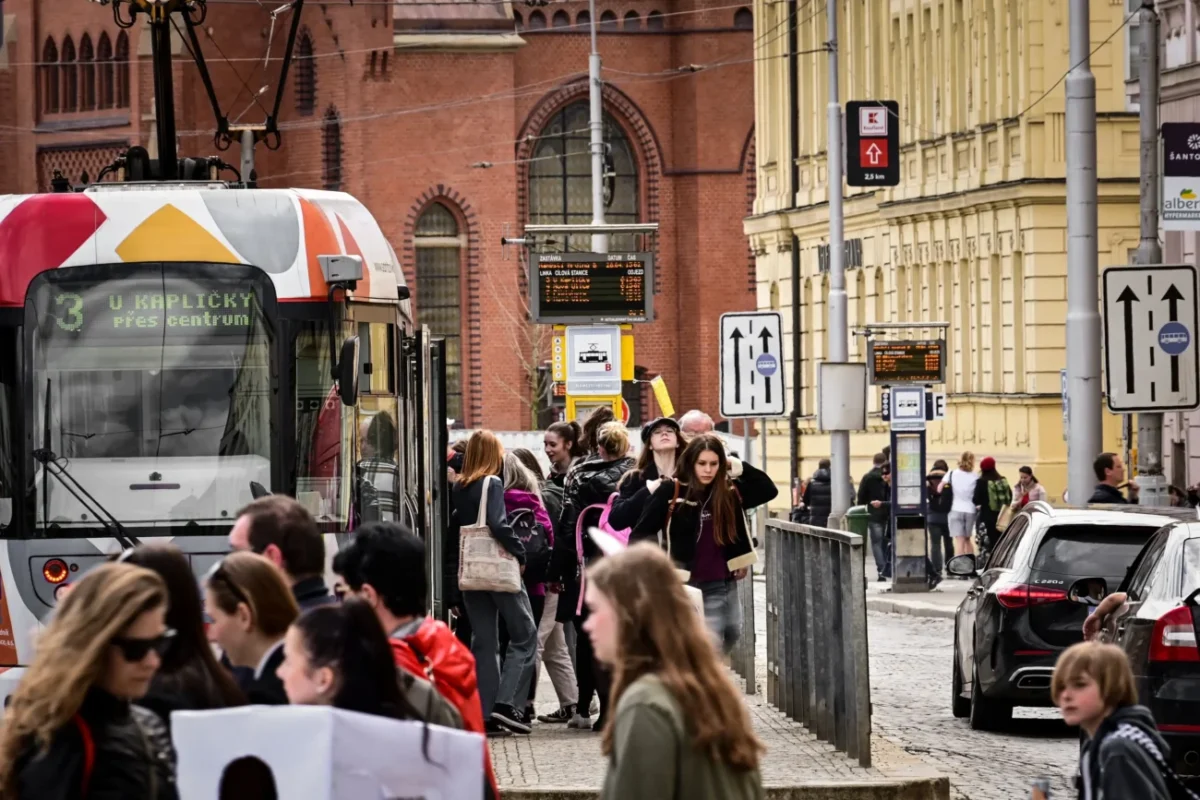 Lidé chodí kolem tramvaje v Olomouci.