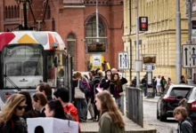 Lidé chodí kolem tramvaje v Olomouci.