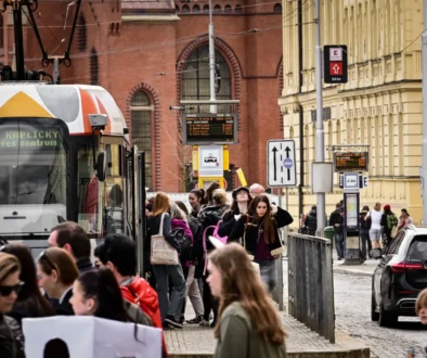 Lidé chodí kolem tramvaje v Olomouci.