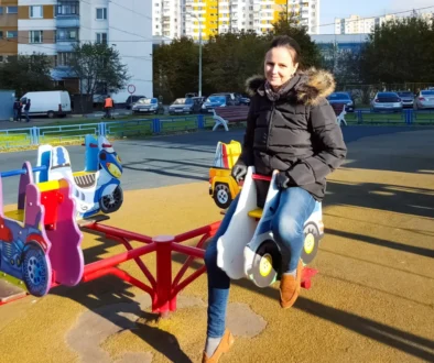 Žena je na dětském kolotoči.